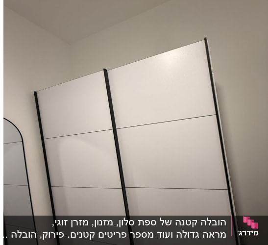 ארון לבן עם דלתות שחורות בחדר